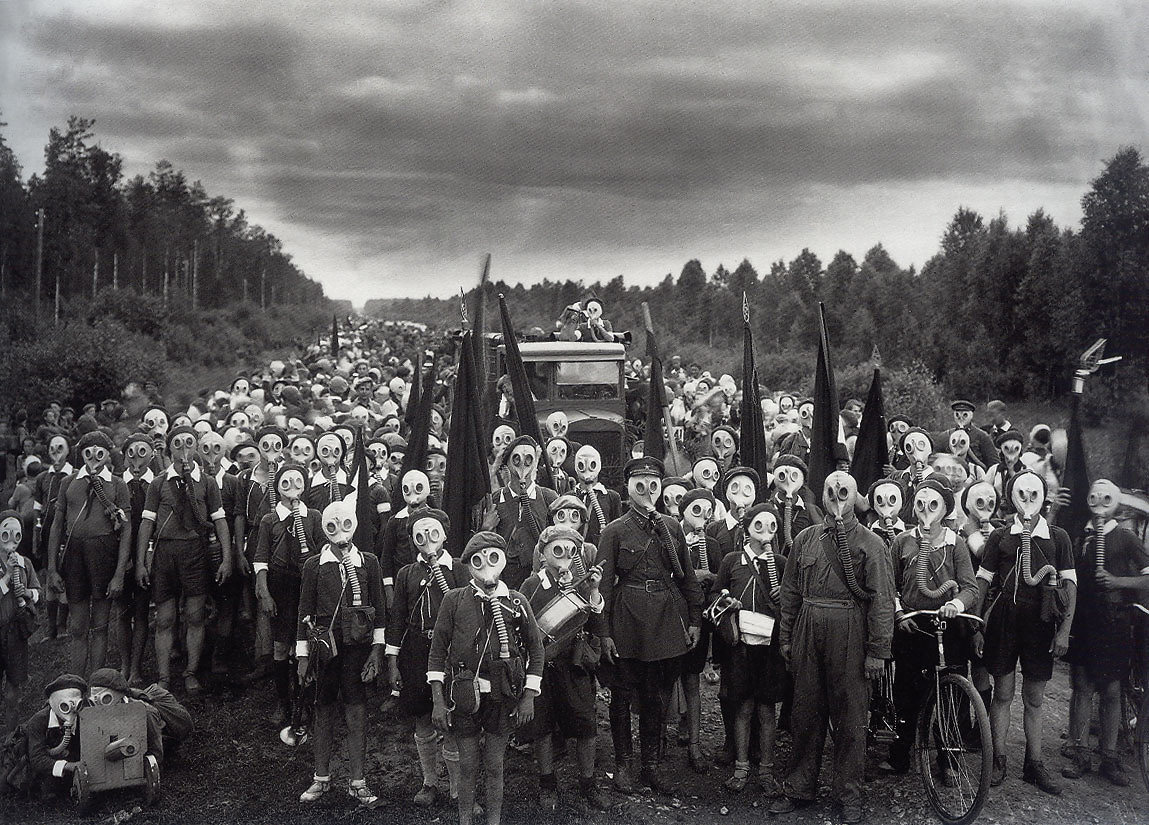 A snapshot of Russia's Young Pioneers in 1937, wearing gas mask and holding different military weapons.