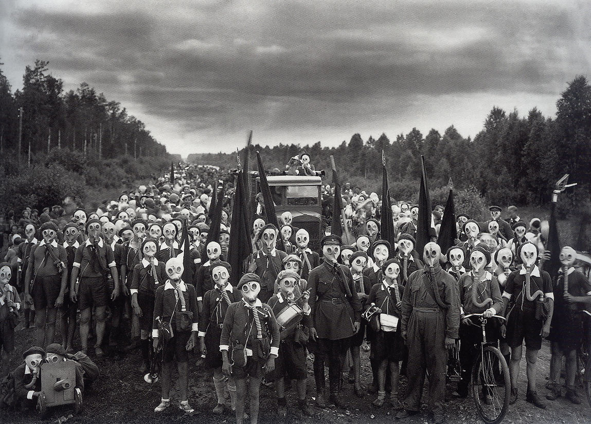 A snapshot of Russia's Young Pioneers in 1937, wearing gas mask and holding different military weapons.
